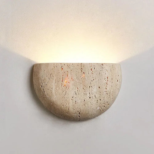 Half-dome stone wall light glowing on a plain wall