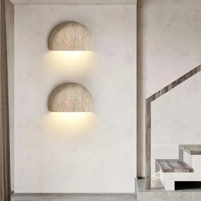Two half-dome stone wall lights stacked beside a staircase