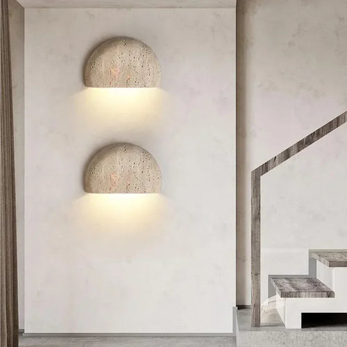Two half-dome stone wall lights stacked beside a staircase