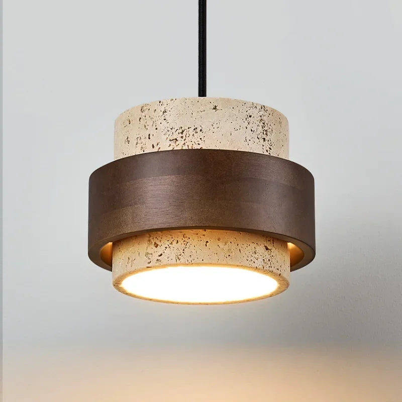 Stone and walnut pendant light seen from slightly below with warm glow