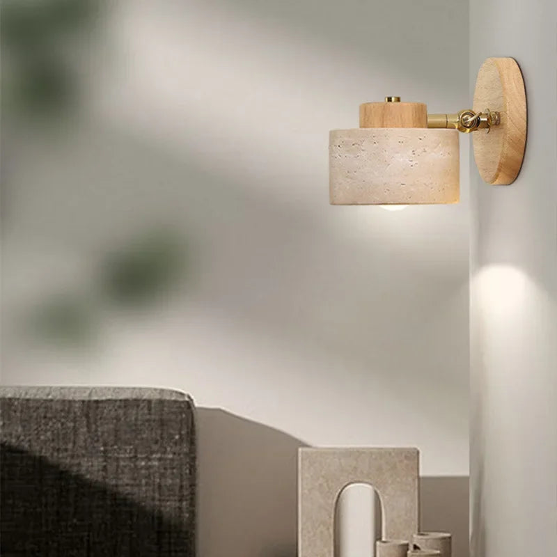 Stone wall light with a natural wood arm against a soft grey wall