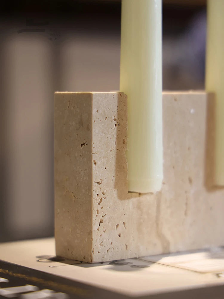 Close-up of the pitted travertine surface beside a candle slot