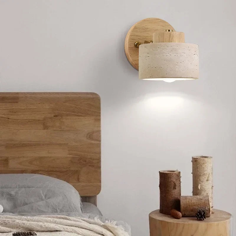 Stone wall light on a natural wood mount above a bedside table