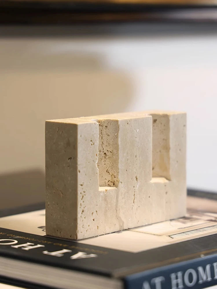 Close-up of a beige travertine block with two candle slots