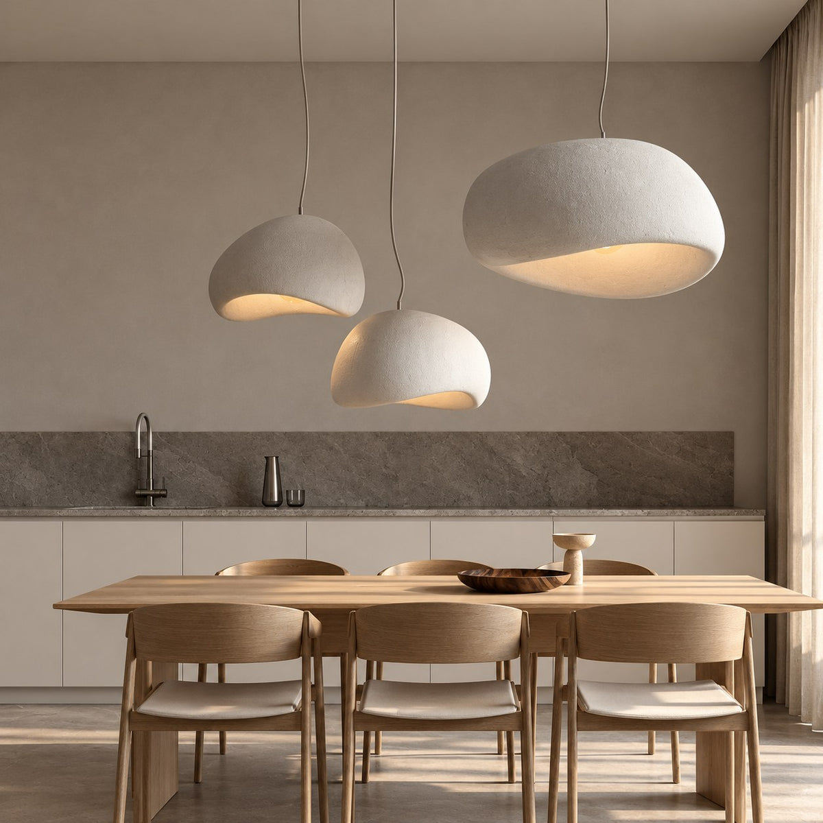 Three white pendant lights over a dining table (sold individually)